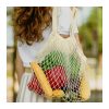 Custom Cotton Net Tote Bag, 5L Mesh Shopper with Fold-Away Pouch 10 A shopper carrying a cotton net tote filled with fruit and vegetables over one shoulder, Singapore