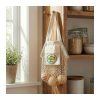 Branded cotton mesh tote hanging on a kitchen hook beside pantry jars and a plant, Singapore