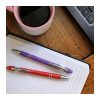 Two aluminium stylus ballpoint pens resting on an open notebook beside a cup of coffee and a laptop, Singapore